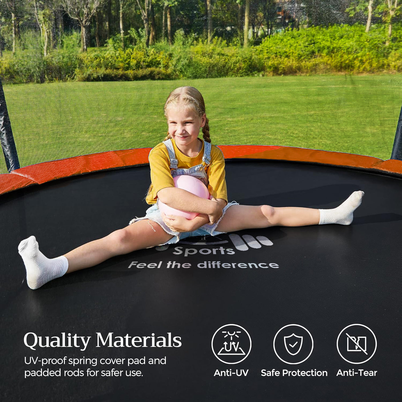 Child sitting on a trampoline with green grass and trees in the background