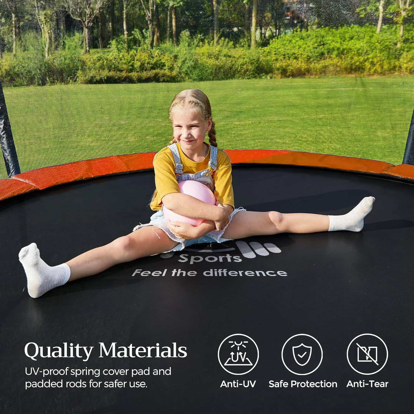 Child sitting on a trampoline with green grass and trees in the background