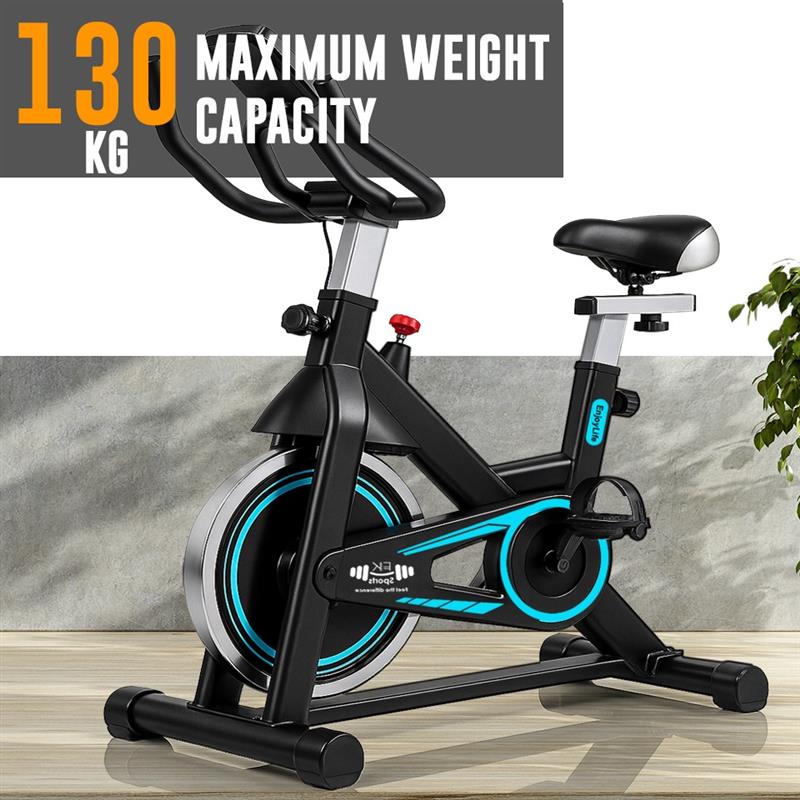 Black exercise bike with blue accents on a wooden floor, featuring a maximum weight capacity of 130 kg.