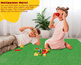 Two children playing with colorful blocks on a green EVA mat in a bright room.