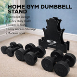 Black dumbbells with a home gym dumbbell stand on a carpeted floor.