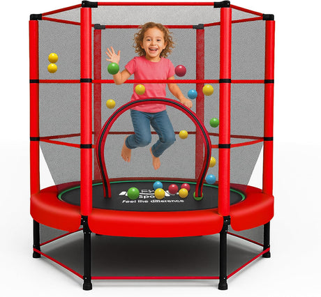 Child playing on a red kid trampoline with safety net and colorful balls.